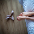 © nickolya - Close-up of the feet of a young woman lying on the bed