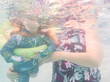 © Austockphoto - Underwater shot of woman playing with toddler grandchild in backyard pool in Australia