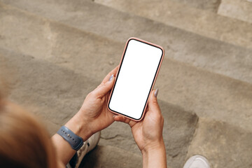 Mockup woman's hand holding using smart phone with white blank screen POV  mobile app design and advertising, online marketing