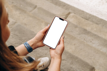 Mockup woman's hand holding using smart phone with white blank screen POV  mobile app design and advertising, online marketing