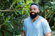 © Wavebreak Media - Standing African American man admiring backyard garden, with lush greenery, copy space