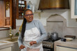 © Sabrina - Happy senior african woman dancing in kitchen while cooking dinner - Joyful elderly lifestyle and food concept