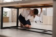 © New Africa - Scared young woman hiding under office desk during earthquake