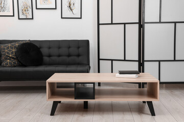 Aufkleber - Books on stylish coffee table near black sofa in room