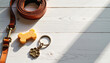 © Mia  - Pet accessories laid out on wooden surface with leash, keychain, and treat during afternoon sunlight