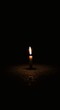 © luwie - A single lit candle surrounded by darkness, representing hope in despair