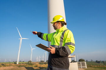 Wall Mural - engineer wearing uniform inspection and survey work in wind turbine farms rotation to generate elect
