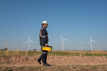 Wall Mural - engineer wearing uniform inspection and survey work in wind turbine farms rotation to generate elect