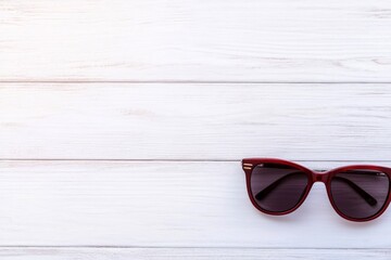 Leinwandbilder - A single pair of stylish sunglasses featuring bold frames rests on a bright white surface, creating soft-edged shadows while leaving ample space on the left