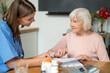 © zinkevych - Nurse supporting senior patient with taking medication offering help and care for disease treatment