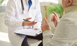 © Studio Romantic - Senior sick man talking to male doctor or nurse in white uniform sitting in clinic during medical examination. Physician consulting his elderly patient in office. Medicine concept.