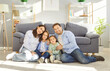 © Studio Romantic - Happy parents, cute kids portrait having fun sitting together on warm floor, cheerful couple laughing playing with little active children son, daughter in living room at home, family funny activity