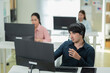 © whyframeshot - attractive young businesman wearing a headset and sitting alone in her office Telemarketing agent, pc and microphone at help desk, consulting or listen for tech support