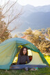© zhukovvvlad - happy smiling child sitting in a tent against the backdrop of the mountains. child in a tent.  outdoor recreation.