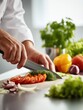 © Blackmint Studio - A chef’s hands are focused on slicing vibrant vegetables, including tomatoes, onions, and herbs, in a well-equipped kitchen. The atmosphere is lively as preparations for a meal are underway