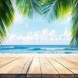 © Oleksandr Sylenko - Empty background with wooden floor on beach with palm trees. banner for advertising product. Wooden tabletop in front. blurred background. empty bar counter