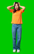 © fotofabrika - Surprised woman expressing shock while standing on a bright green background in a casual outfit