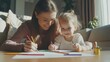 © theo - A heartwarming scene of a mother and daughter engrossed in drawing together