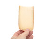 © Petra Richli - Isolated Raclette cheese slice held in hand. Woman holding freshly sliced Raclette cheese. Traditional Swiss or French meal. Melting cheese for grill trays. Selective focus.