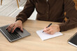 © New Africa - Senior man taking notes while learning online at desk indoors, closeup. Self-study