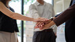 © wattana - Business team stacking hands in unity. Team spirit, partnership, and corporate culture concept.