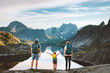 © EVERST - Family traveling in Norway parents hiking with child in Lofoten islands active summer vacations outdoor. Father, mother and kid backpacking in mountains enjoying lake landscape, healthy lifestyle tour