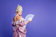 © deagreez - Elegant woman in a baroque gown holding a vintage lace fan against a vibrant violet background