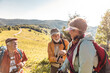 © Marko Geber - Senior hikers trekking together on a scenic mountain trail in sunny weather