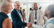 © peopleimages.com - Conference, handshake and welcome with business people at event for global forum, investor summit and networking. Shaking hands, b2b convention and expo with employees for brand exposure seminar