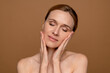 © InsideCreativeHouse - Shot of of happy good-looking middle age woman with beautiful skin smiling at camera closing eyes and touching flawless face skin, posing on brown beige wall background isolated