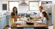 © peopleimages.com - Smile, food and lunch with family at kitchen table for nutrition, bonding and health salad. Vegetables, support and happiness with parents and children eating at home for love, wellness and relax