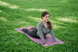 © PSG - Asian woman doing yoga in a garden with trees for health and exercise.