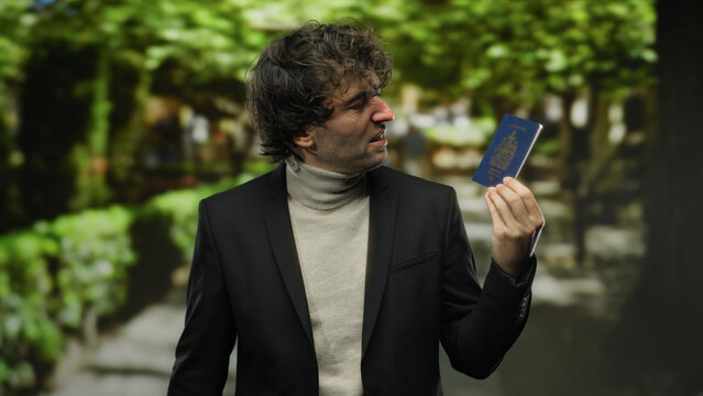 Man holding canadian passport outdoors in a lush green park, conveying a sense of travel, identity, and international exploration with a thoughtful expression.