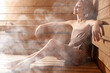 © New Africa - Beautiful woman relaxing surrounded by steam in sauna