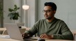© Postmodern Studio - Asian male adult working at laptop in modern office environment