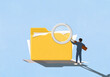 © fStop - Businessman holding large magnifying glass over large messy file folder with paperwork