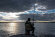 A fisherman catches fish at the Verkh-Isetskoye reservoir at sunset on a summer evening, Yekaterinburg