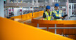 © Gorodenkoff - Female and Male Technicians with a Tablet Computer Monitoring Automated Conveyor Belt with Packages in a Logistics Warehouse. Modern Fulfillment Center with Online Retail Orders