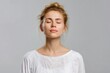 © volga - Calm woman meditating with closed eyes gray background