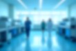 © Kavindu - Blurred Hospital Interior Background with Medical Equipment and Light Blue Color Theme