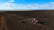 © Павел Чигирь - A red tractor works on a plowed field in spring, Russia farming