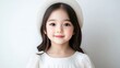 © tugkiara - A young girl wearing a white hat and dress posing for a portrait, soft lighting with a plain background, innocent and serene expression, and studio setting.