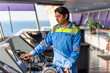 © Mariusz - Chief officer on the bridge of a merchant ship, wearing a light blue uniform with epaulettes, working with pride and confidence - an authentic portrait of leadership at sea. Real workplace.
