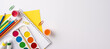 © ActionGP - Creative tools arrangement including watercolors, colored pencils, and paper on white background