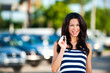 © Eric Hood - Happy smiling young woman at car dealership with new car key