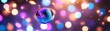 © Kanakorn - Shimmering disco ball surrounded by colorful bokeh lights.