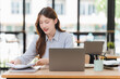 © Kritdanai - Young Woman Working at Desk with Laptop