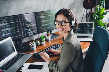 young female software developer working remotely on a programming project, smiling confidently in a 