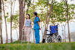© Wanchai - With gentle attention and encouragement, a dedicated female physical therapist assists her patient in practicing rehabilitation exercises in the hospital's outdoor garden.