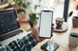 © Deris Firmansyah - Latin indian adult student holding using mock up of cell mobile smartphone with empty blank white screen for advertising. Over shoulder closeup view.